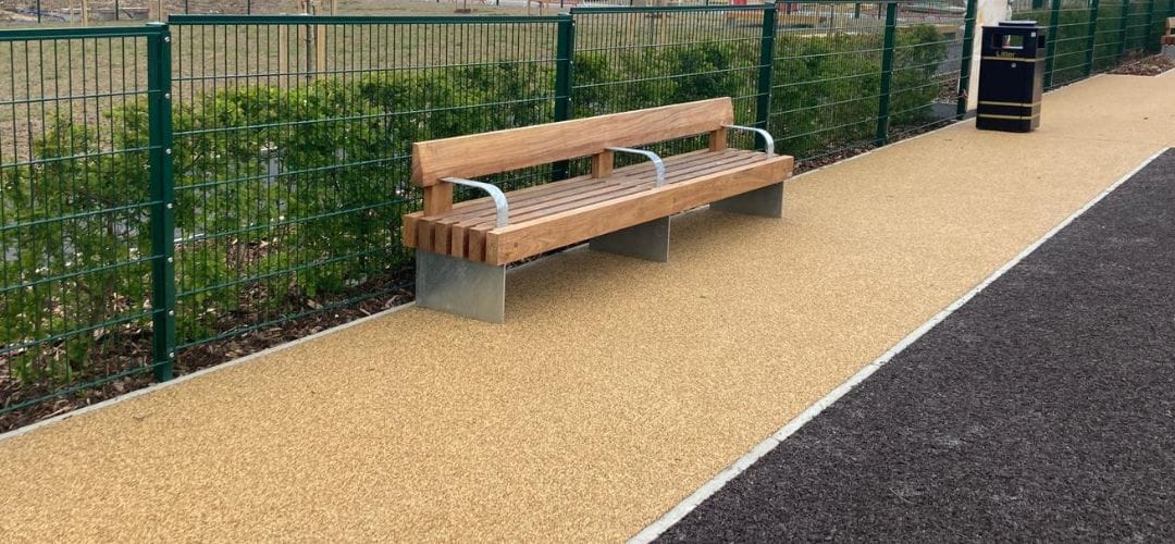 Resin bound gravel pathway with timber bench installed alongside, showing smooth porous surfacing finish.